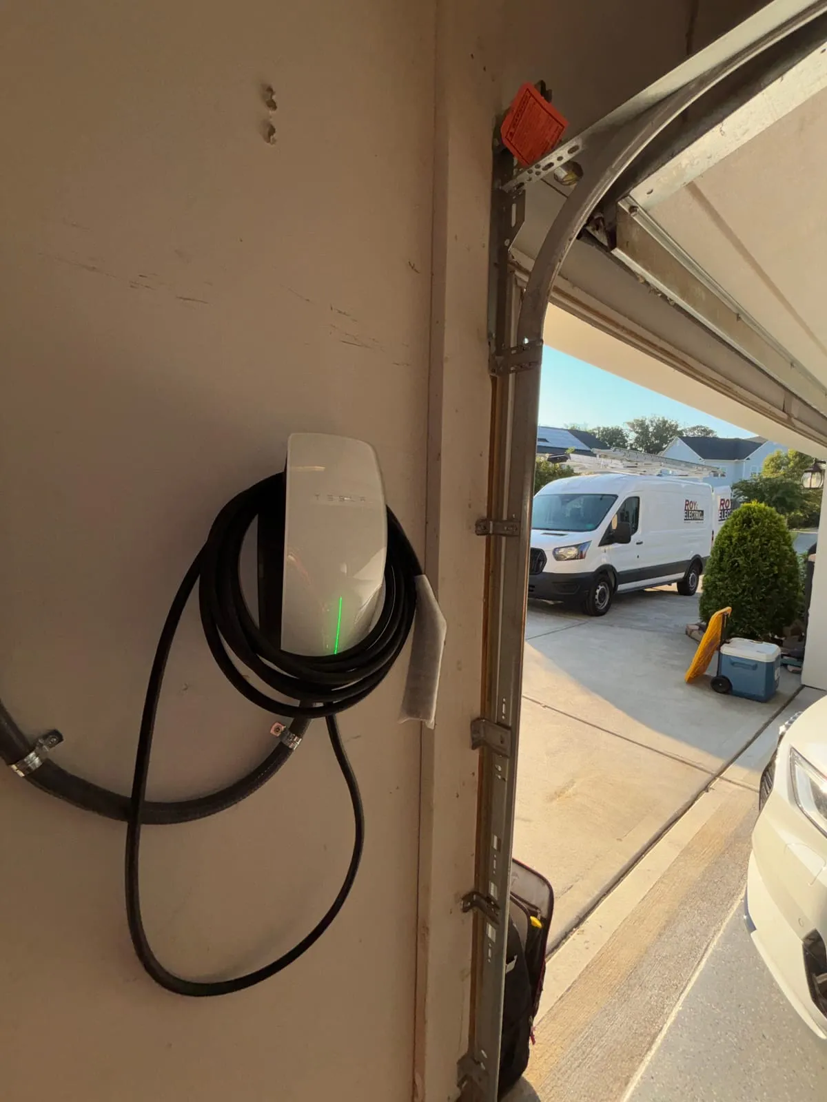 Tesla charger in the garage, Roy Electric van out front